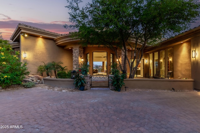 view of front of house featuring a gate and stucco siding