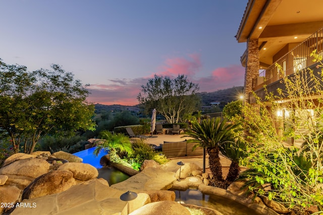 pool at dusk with a patio