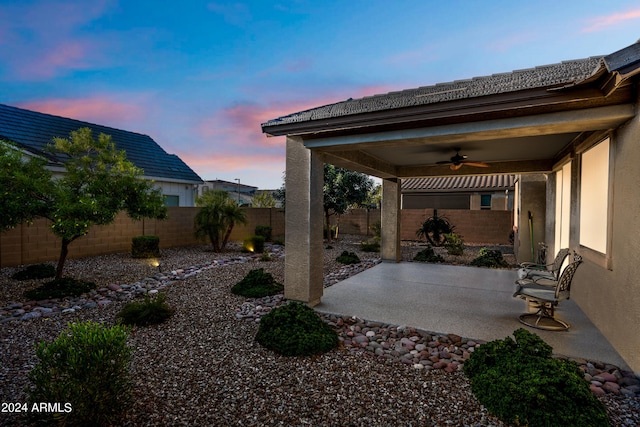 patio terrace at dusk featuring ceiling fan