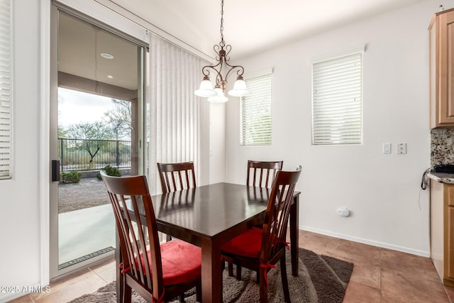 dining area featuring light tile patterned floors and a notable chandelier