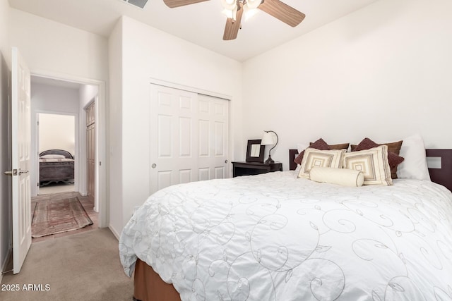 carpeted bedroom with ceiling fan and a closet