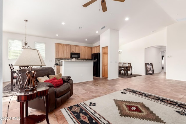 living room featuring ceiling fan and vaulted ceiling