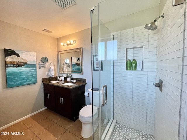 bathroom with vanity, a shower with door, tile patterned flooring, and toilet