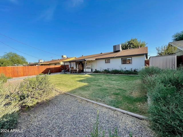 rear view of house with central air condition unit, a lawn, a patio, and a storage shed