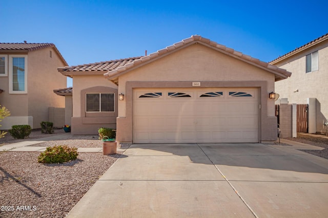 mediterranean / spanish house with an attached garage, driveway, a tiled roof, and stucco siding