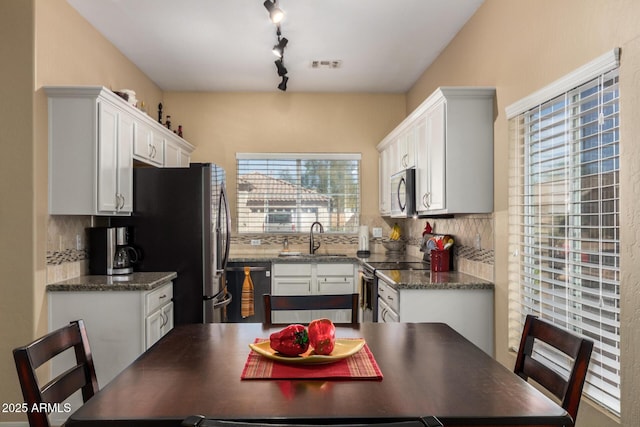 kitchen with a sink, white cabinetry, visible vents, appliances with stainless steel finishes, and tasteful backsplash