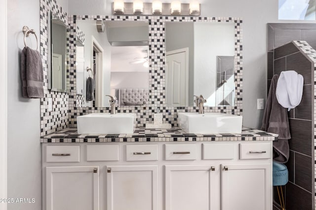 full bath featuring double vanity, a sink, a ceiling fan, and decorative backsplash