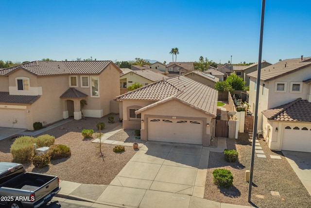 mediterranean / spanish house with an attached garage, a residential view, concrete driveway, and stucco siding