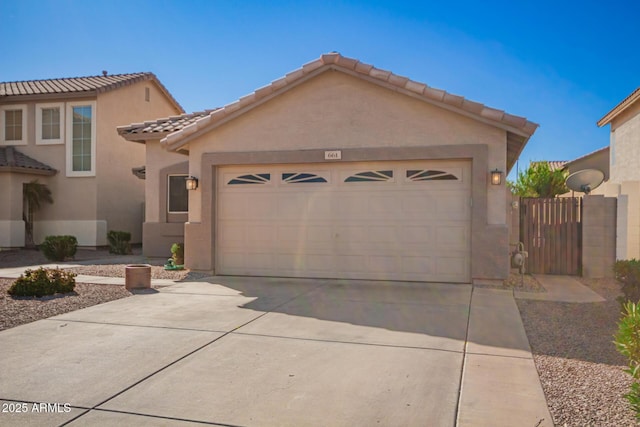 view of front of home featuring a tile roof, driveway, an attached garage, and stucco siding