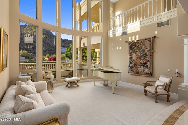 11809 S Montezuma Ct, Phoenix, AZ 85044 - carpeted living room with a towering ceiling, a mountain view, ornate columns, and baseboards