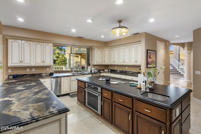 11809 S Montezuma Ct, Phoenix, AZ 85044 - kitchen with stainless steel appliances, a center island, plenty of natural light, decorative columns, and recessed lighting