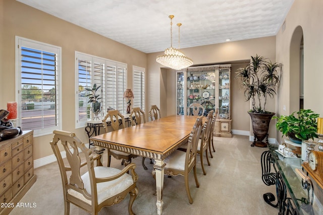 11809 S Montezuma Ct, Phoenix, AZ 85044 - dining room featuring arched walkways, light colored carpet, and baseboards