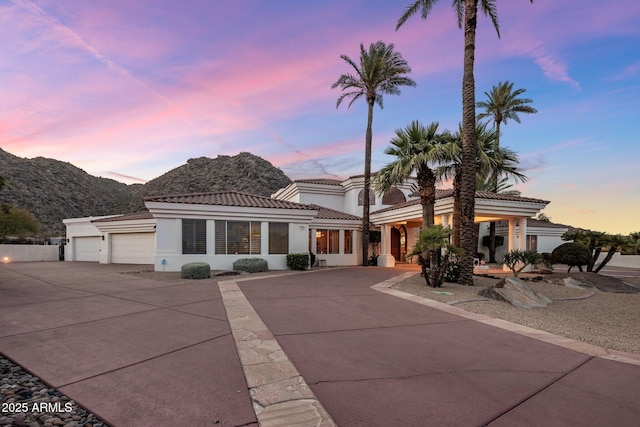 11809 S Montezuma Ct, Phoenix, AZ 85044 - mediterranean / spanish-style home with driveway, stucco siding, an attached garage, a tile roof, and a mountain view
