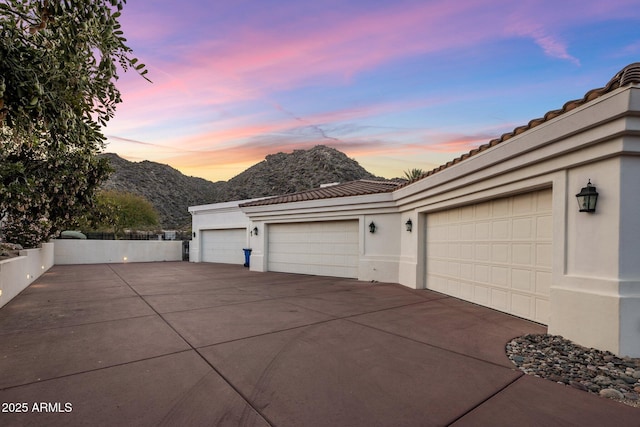 11809 S Montezuma Ct, Phoenix, AZ 85044 - garage at dusk with a mountain view and concrete driveway