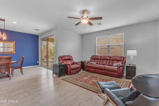 696 W Glen Canyon Dr, San Tan Valley, AZ 85140 - living area featuring visible vents, ceiling fan with notable chandelier, baseboards, and wood finished floors