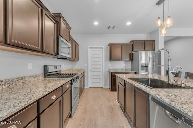 696 W Glen Canyon Dr, San Tan Valley, AZ 85140 - kitchen featuring visible vents, pendant lighting, a sink, light wood-style floors, and appliances with stainless steel finishes