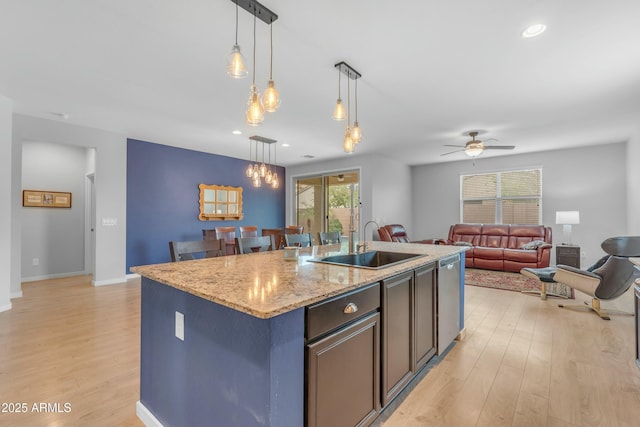696 W Glen Canyon Dr, San Tan Valley, AZ 85140 - kitchen featuring a ceiling fan, a kitchen island with sink, a sink, pendant lighting, and light wood-type flooring