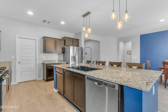 696 W Glen Canyon Dr, San Tan Valley, AZ 85140 - kitchen with light wood finished floors, visible vents, a sink, stainless steel appliances, and a kitchen island with sink