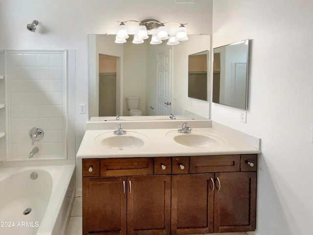 bathroom featuring double sink, large vanity, and toilet