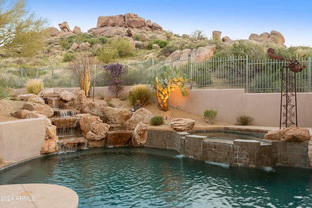 view of pool with an in ground hot tub and pool water feature