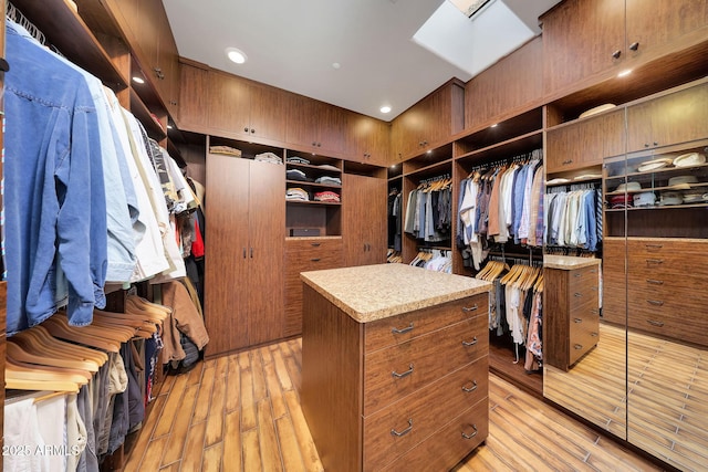 walk in closet with light hardwood / wood-style floors