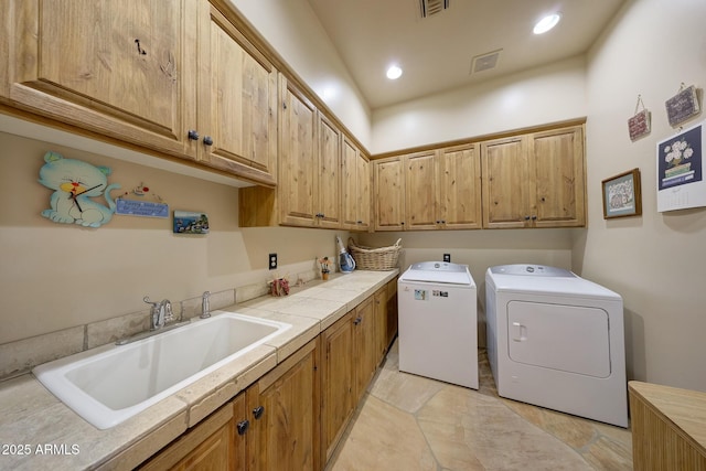 laundry room featuring separate washer and dryer, sink, light tile patterned flooring, and cabinets