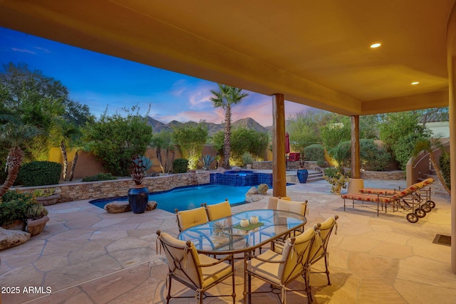 patio terrace at dusk featuring an in ground hot tub