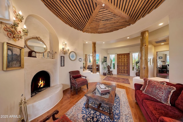 living room with hardwood / wood-style floors, beam ceiling, wooden ceiling, and a premium fireplace