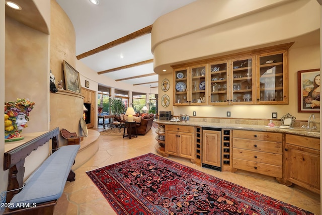 bar featuring sink, wine cooler, light tile patterned floors, light stone countertops, and beamed ceiling