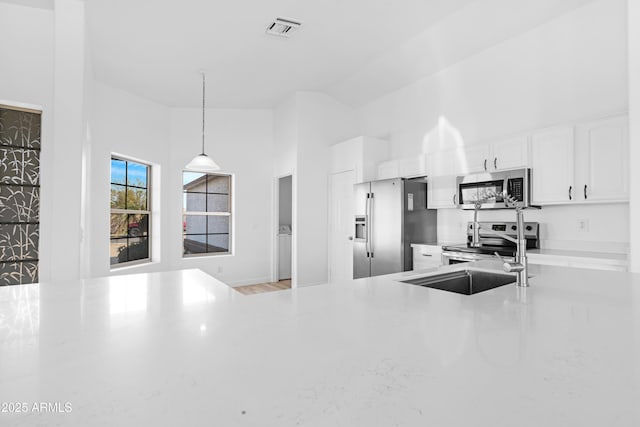 kitchen featuring stainless steel appliances, visible vents, white cabinets, light countertops, and pendant lighting