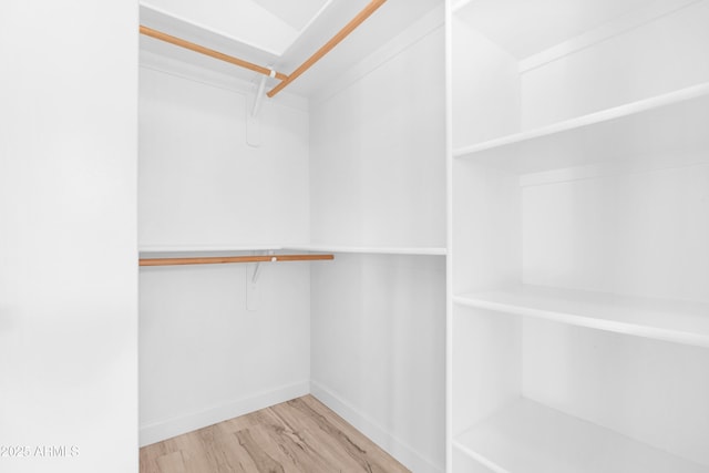 walk in closet with light wood-style flooring