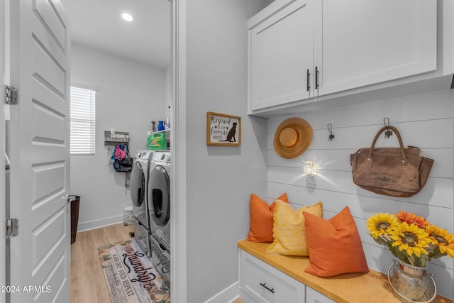 clothes washing area with light wood-type flooring and independent washer and dryer