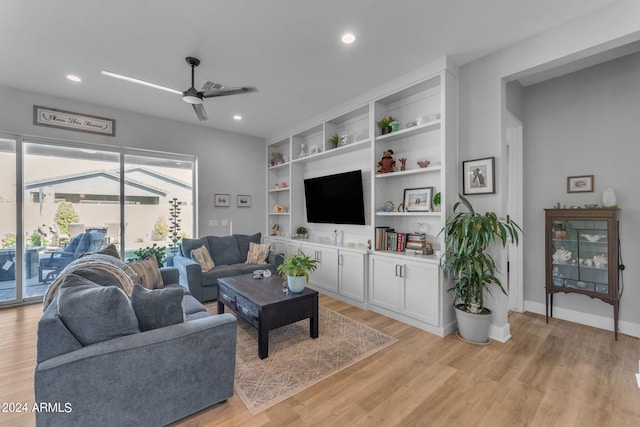 living room with ceiling fan and light hardwood / wood-style flooring