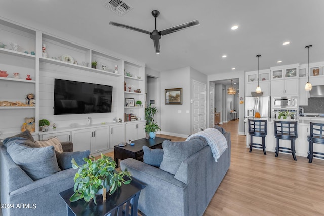 living room featuring ceiling fan and light hardwood / wood-style flooring