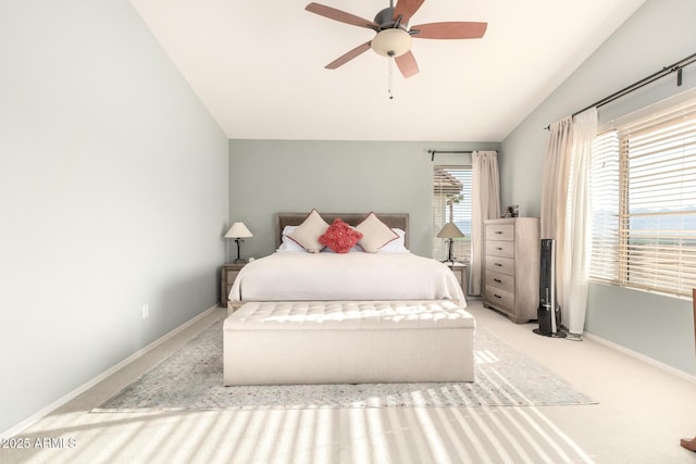 bedroom featuring baseboards, vaulted ceiling, carpet flooring, and a ceiling fan