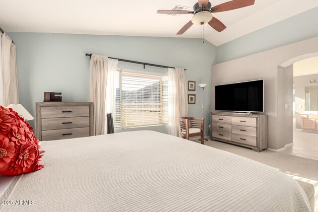 carpeted bedroom with baseboards, ceiling fan, arched walkways, lofted ceiling, and ensuite bath