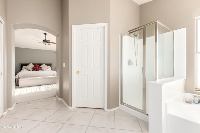 ensuite bathroom with a shower stall, baseboards, tile patterned floors, a ceiling fan, and ensuite bath