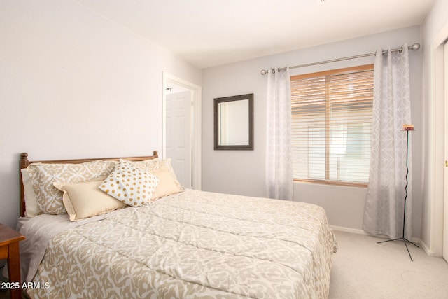 bedroom with light carpet and baseboards