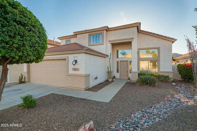 view of front facade with stucco siding, an attached garage, a tiled roof, and concrete driveway