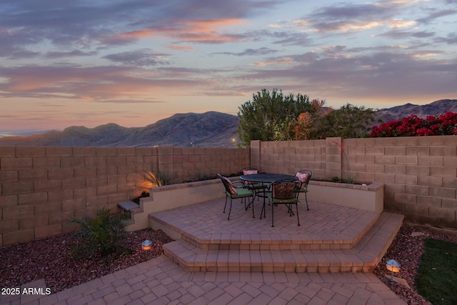 view of patio / terrace with a fenced backyard, outdoor dining area, and a mountain view