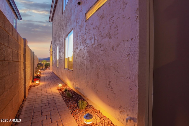 view of home's exterior featuring stucco siding and fence