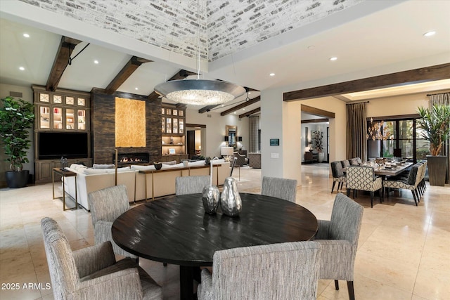 tiled dining space featuring beamed ceiling and a large fireplace