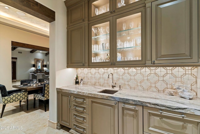 bar featuring light stone counters, light tile patterned flooring, sink, and backsplash