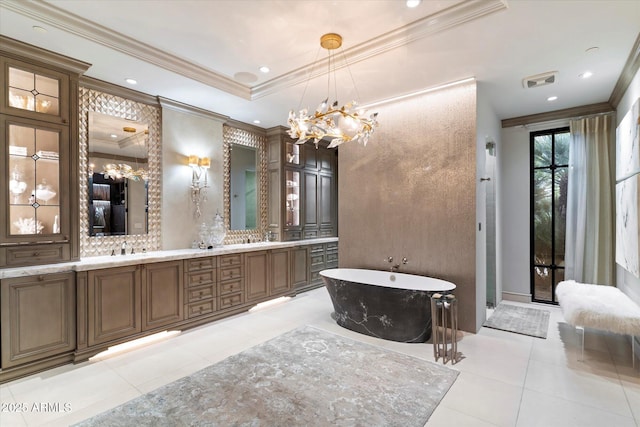 bathroom featuring tile patterned floors, ornamental molding, vanity, a tray ceiling, and a bathtub