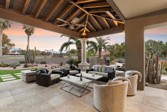 patio terrace at dusk featuring a gazebo, ceiling fan, and outdoor lounge area