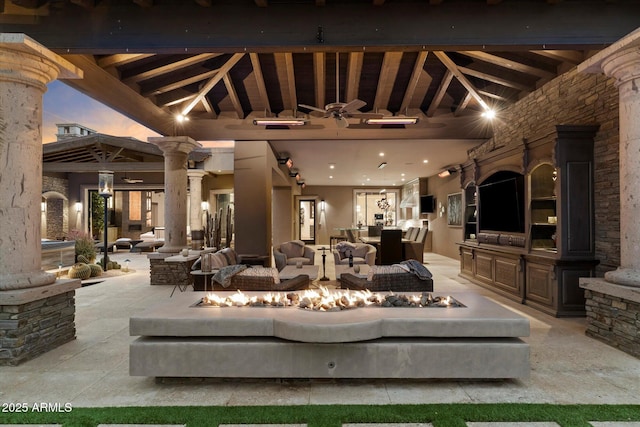 patio terrace at dusk with an outdoor living space with a fire pit