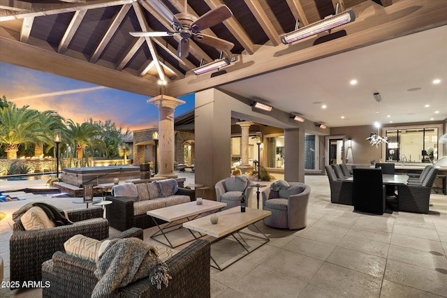 patio terrace at dusk with outdoor lounge area, ceiling fan, and a hot tub