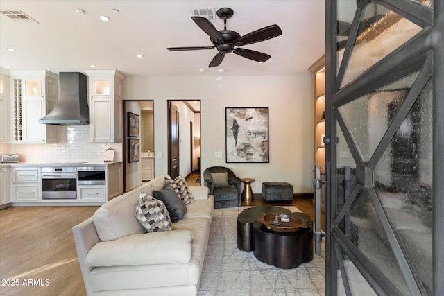 living room with light hardwood / wood-style floors and ceiling fan