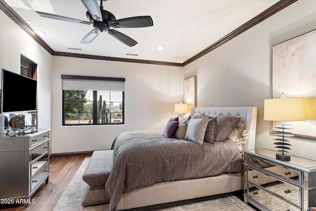 bedroom with crown molding, ceiling fan, and dark hardwood / wood-style floors