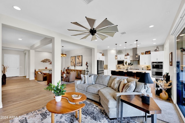 living room with a notable chandelier and light wood-type flooring